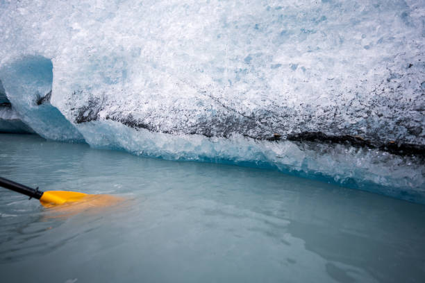 kajakfahren in alaska, gelbes kanuboot mit paddel in der nähe des eisbergs - extreme sports kayaking kayak adventure stock-fotos und bilder