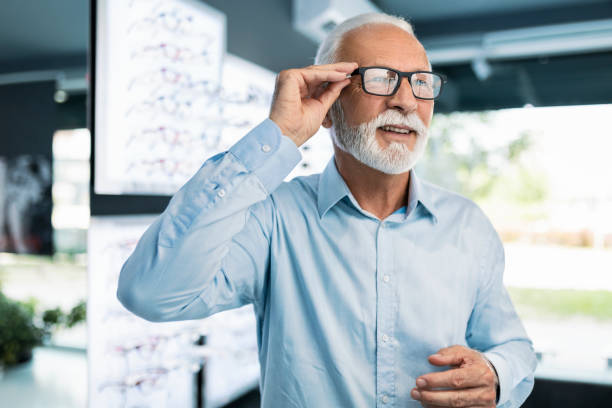 istock Senior man looking at different new eyeglasses 1406024869