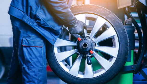 istock Auto mechanic uses tire balancing machine and turning tire 1406024899