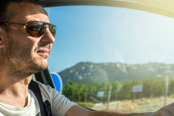istock man driving sun face glare dazzled 1406025959