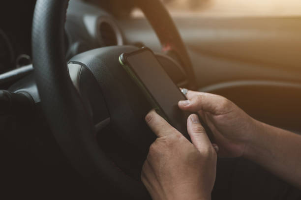 istock Young man driving car and using mobile phone 1406026584
