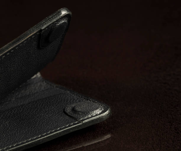 istock Part of a black leather wallet on a black background. 1406028277