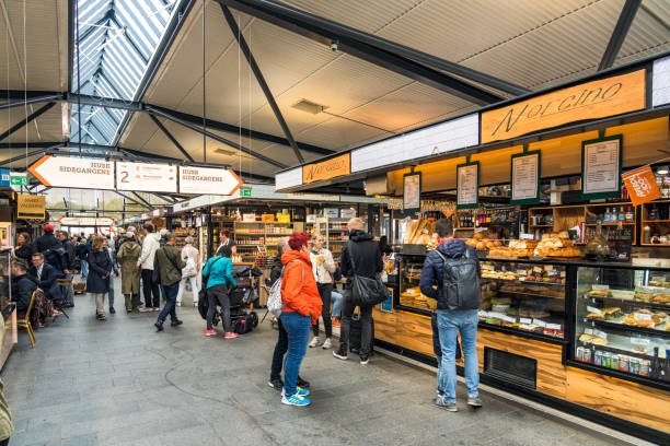 Copenhagen, Denmark - People inside one of the Torvehallerne food markets in central Copenhagen, with multiple cafes and food shops available in one place.