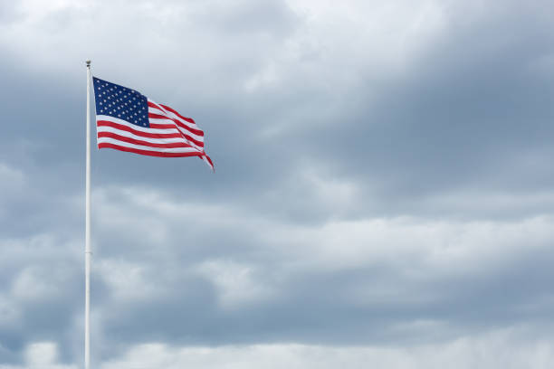 istock American flag on the gray sky. Cloudy day 1406033326