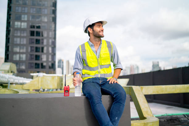 istock Caucasian professional engineer or technician sit on terrace of construction with relax after work and look around with happiness for success of the project. 1406033492