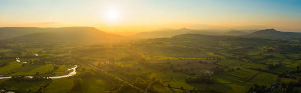 istock Aerial panorama golden sunlight over idyllic rural landscape fields mountains 1406034218