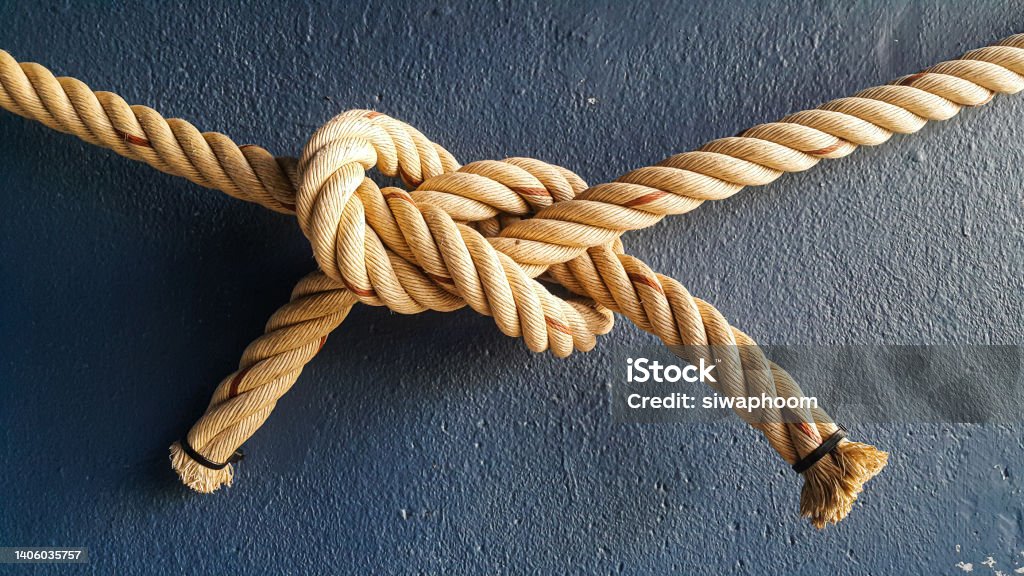 tying ropes in a correlation pattern Ropes were tied together and hung on the blue wall Tying Stock Photo