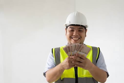 Asian engineer holding money