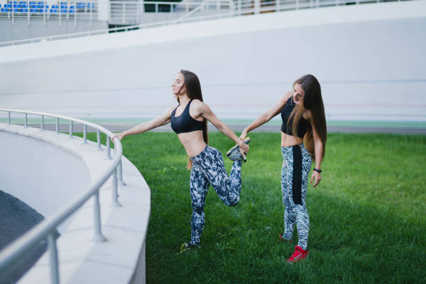 sports and fitness outside the gym. young fit women with perfect bodies in sportswear train together outdoors on the playground. - playing field effort outdoors human age imagens e fotografias de stock