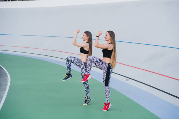 sports and fitness outside the gym. young fit women with perfect bodies in sportswear train together outdoors on the playground. - playing field effort outdoors human age imagens e fotografias de stock