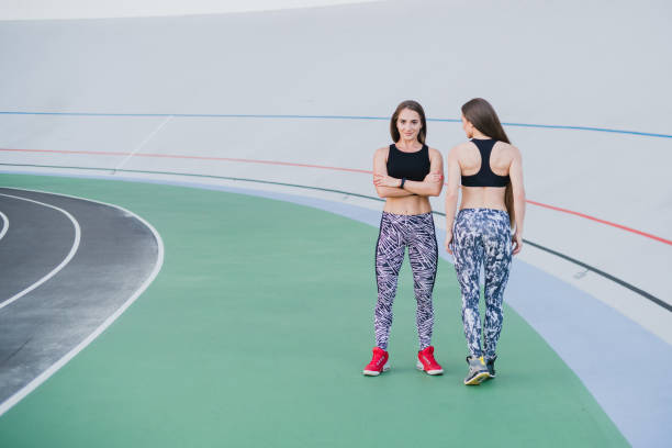 sports and fitness outside the gym. young fit women with perfect bodies in sportswear train together outdoors on the playground. - playing field effort outdoors human age imagens e fotografias de stock