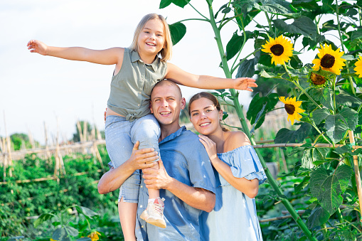 Happy family spending time together near sunflowers