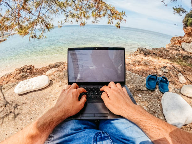 istock Young Man Working On Laptop At The Beach 1406041908