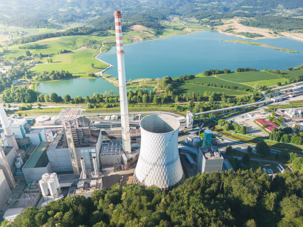 istock Big coal power station with active cooling tower emitting gases into environment 1406045463