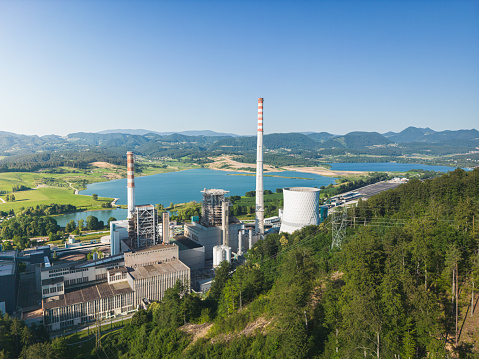 Aerial view of a coal fired power station. Large cooling towers emitting steam into to air. Large cause for pollution which leads to global warming and climate change. This also leads to environmental degradation.