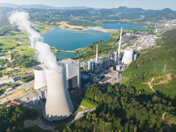 istock Big coal power station with active cooling tower emitting gases into environment 1406045477