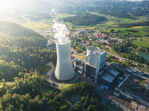 Aerial view of a coal fired power station. Large cooling towers emitting steam into to air. Large cause for pollution which leads to global warming and climate change. This also leads to environmental degradation.