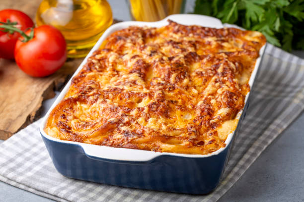 istock Pasta casserole bechamel sauce topped with melted mozzarella cheese and served in a white baking dish on a table (Turkish name; firinda makarna or firin makarna) 1406051954