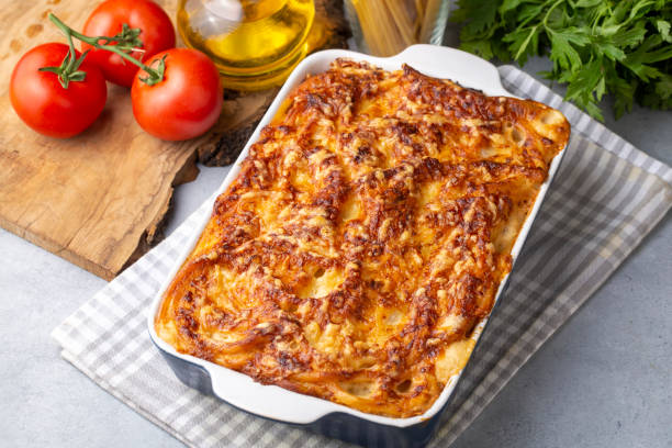 istock Pasta casserole bechamel sauce topped with melted mozzarella cheese and served in a white baking dish on a table (Turkish name; firinda makarna or firin makarna) 1406053924