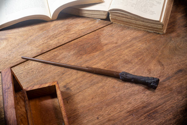 istock magic wand on a wooden table with an open book. 1406055829