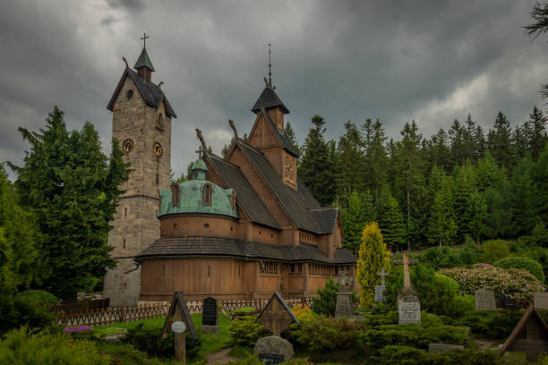 Wooden church with stone tower in cloudy spring day in Karpacz town stock photo