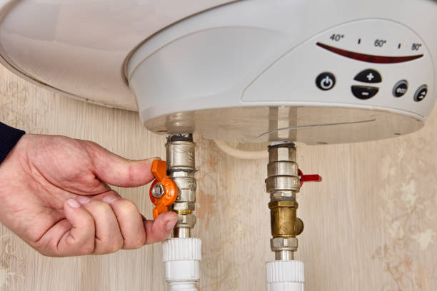 istock Hand turning ball valve with butterfly handle for electric tank water heater starting, using electricity to heat water for home water supply. 1406056777