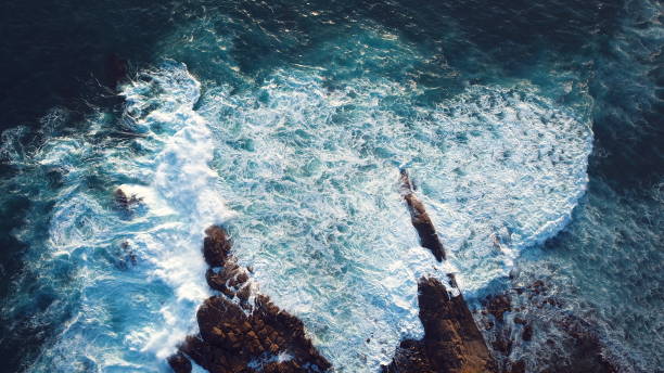 istock Waves striking against a rocky cliff 1406056988