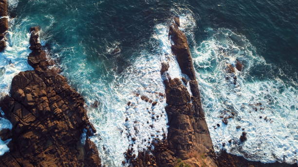istock Waves striking against a rocky cliff 1406058028