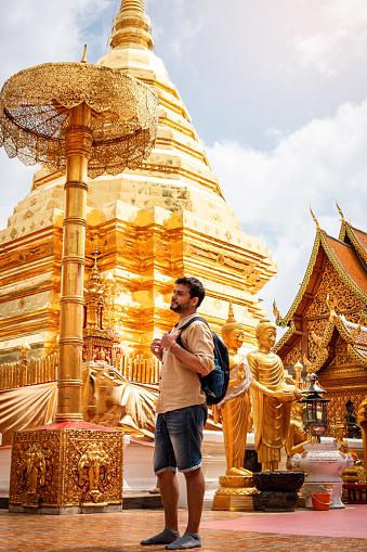 Young tourist touring Doi Suthep, Chiang Mai, Thailand. Tourist walking through temple in northern Thailand
