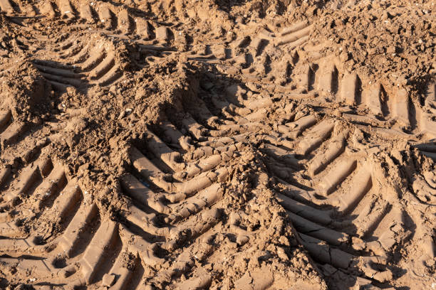 istock Wet soil ground, Car tire tracks footprint on construction site 1406061275