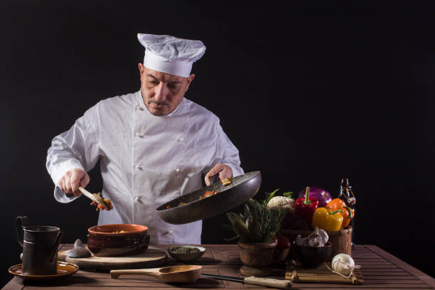 istock Male chef in white uniform preparing food plate with vegetables 1406062263