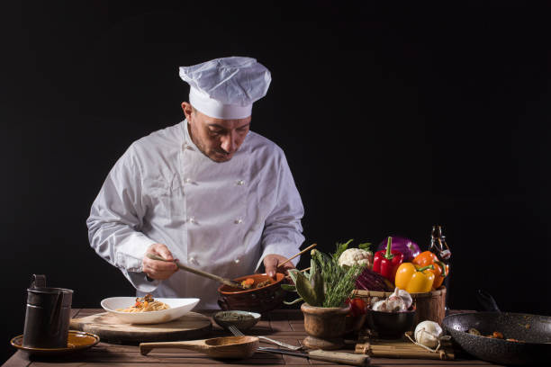 istock Male chef in white uniform preparing food plate with vegetables 1406062270