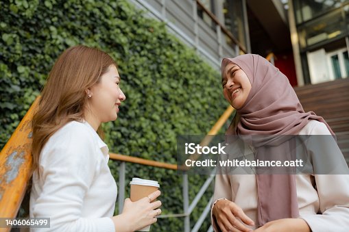 istock Two young Asian woman freelancers chatting on the stairway to their office during lunch break. 1406065499