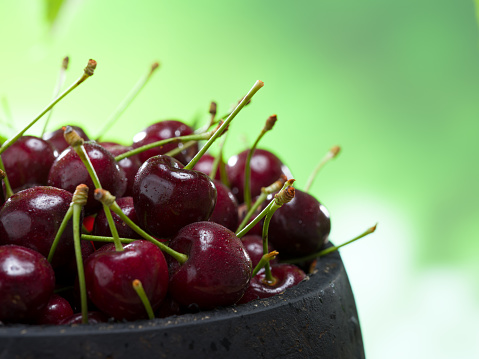 Close-up view of beautiful cherries in rustic wooden bowl. Organic farm products. Natural food concept. Ripe cherries