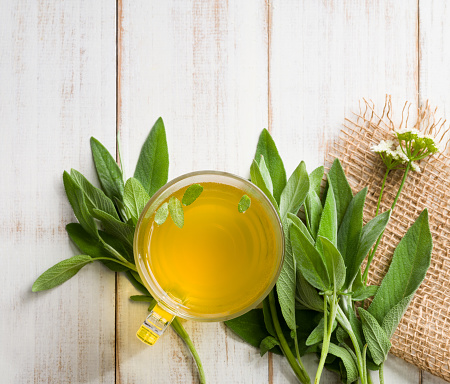 Cup of sage tea on the wooden table. Herbal teas concept.