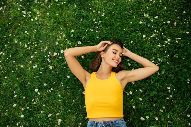 istock Smiling young woman lying on grass 1406071471