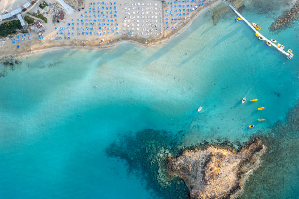 istock Beach umbrellas in a row at fig tree bay beach Protaras Cyprus. Summer vacations holiday resort. 1406072661