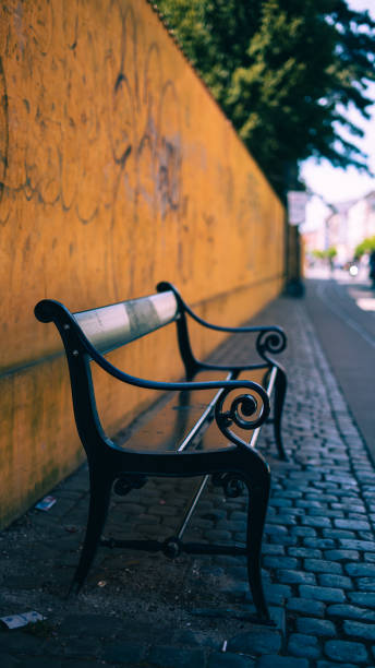 istock Bench in Copenhagen streets in front of yellow wall 1406076126