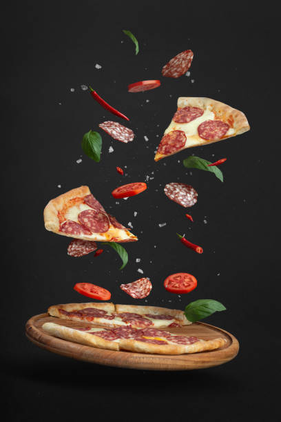 istock flying pizza with ingredients on a black background 1406076242