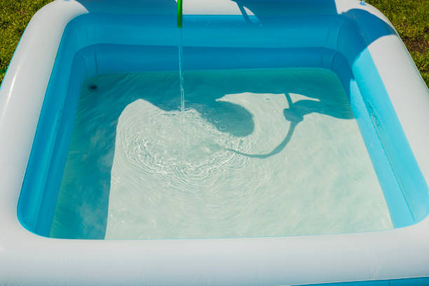 istock Close up view of water running into white inflatable pool. 1406080537