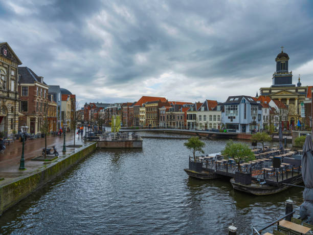 istock Canal side Dutch architecture and boat restaurant in Leiden, Netherlands 1406083325