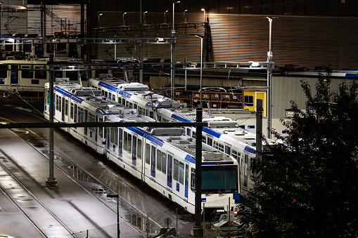 M1 Metros of Lausanne are parking at the lot at night after raining. The parking lot is in front of EPFL.