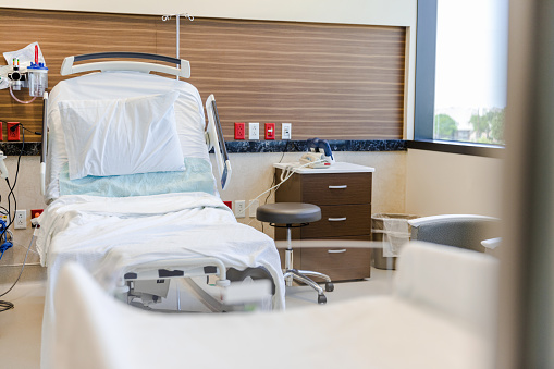 Hospital bed in patient room with sun light for background