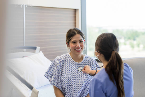 mujer adulta joven sonríe al cardiólogo - patient female hospital recovery fotografías e imágenes de stock