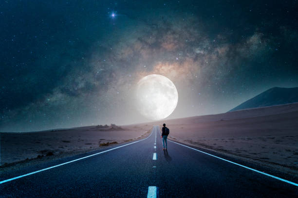 straße zum mond in der wüste bei nacht mit silhouette einer person - walking at night stock-fotos und bilder
