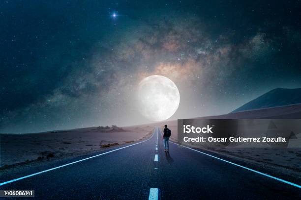 Road To The Moon In The Desert At Night With Silhouette Of A Person Stock Photo - Download Image Now