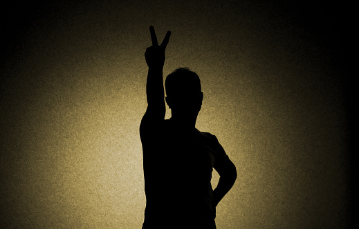 Front view of man making the victory sign.