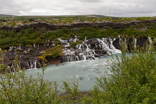 Hraunfossar is a series of waterfalls formed by rivulets streaming over a distance of about 900 metres out of the Hallmundarhraun, a lava field which flowed from an eruption of one of the volcanoes lying under the glacier Langjökull.