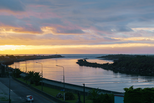 Dark cloudy sky in sunset colours over Grey River and West Coast at Greymouth New Zealand.