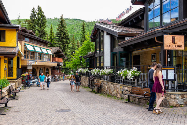 vacation town in rocky mountains of colorado with people walking by shops stores and restaurants on cobblestone of gore creek drive - vail eagle county colorado stockfoto's en -beelden